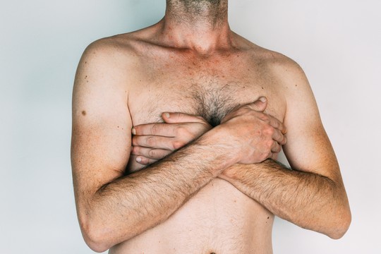mężczyzna zakrywa rękami klatkę piersiową